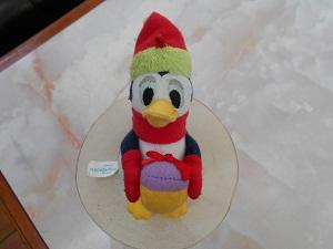 赤い帽子、マフラー、手袋をしたペンギンのぬいぐるみの正面からの写真