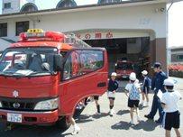 ドアが空いている消防車と見学に訪れた児童たちの写真
