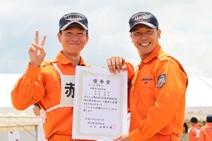 賞状を手にピースサインをする2人の隊員の写真
