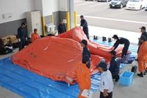 援助隊資機材取扱訓練で床に広げた大型テントが少し膨らんだ写真