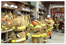 緊急出動の準備で消防服を着る消防士たちの写真