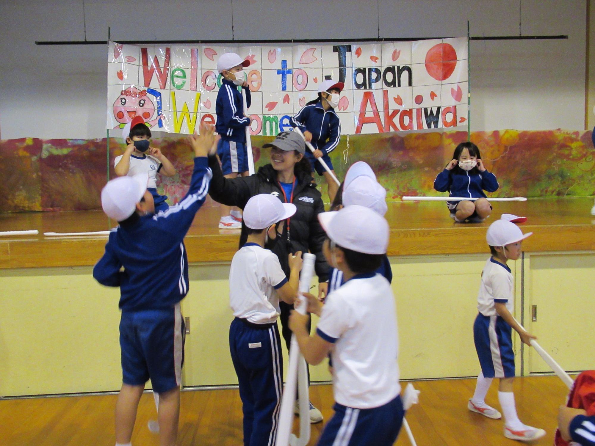 ジュリアさんとハイタッチをする磐梨小学生