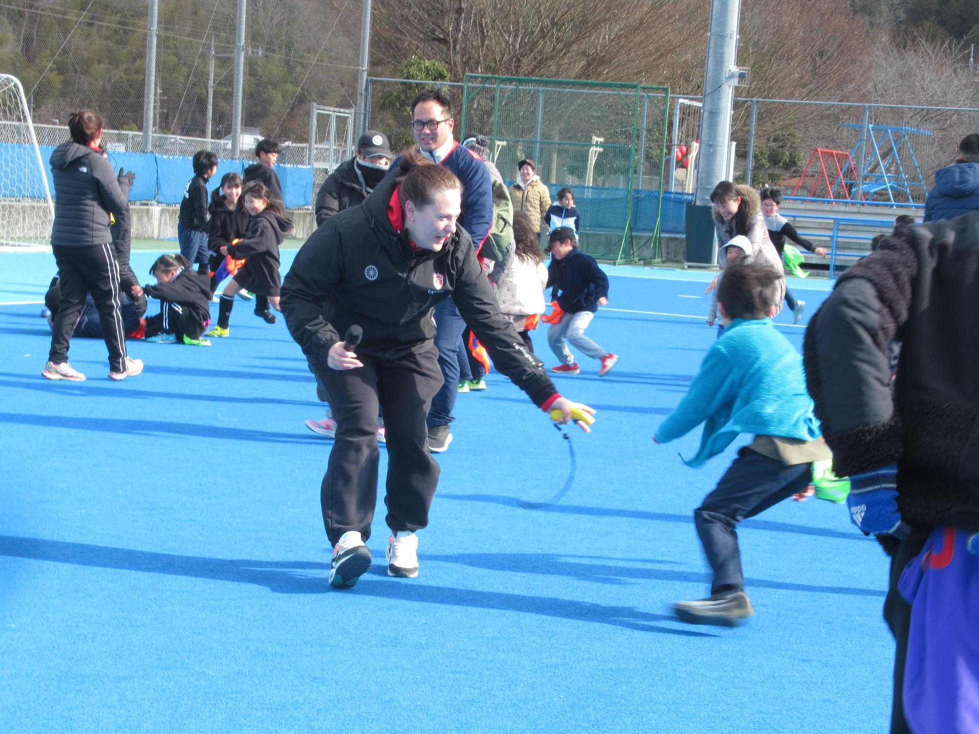 おにごっこをする参加者とカナダコーチ