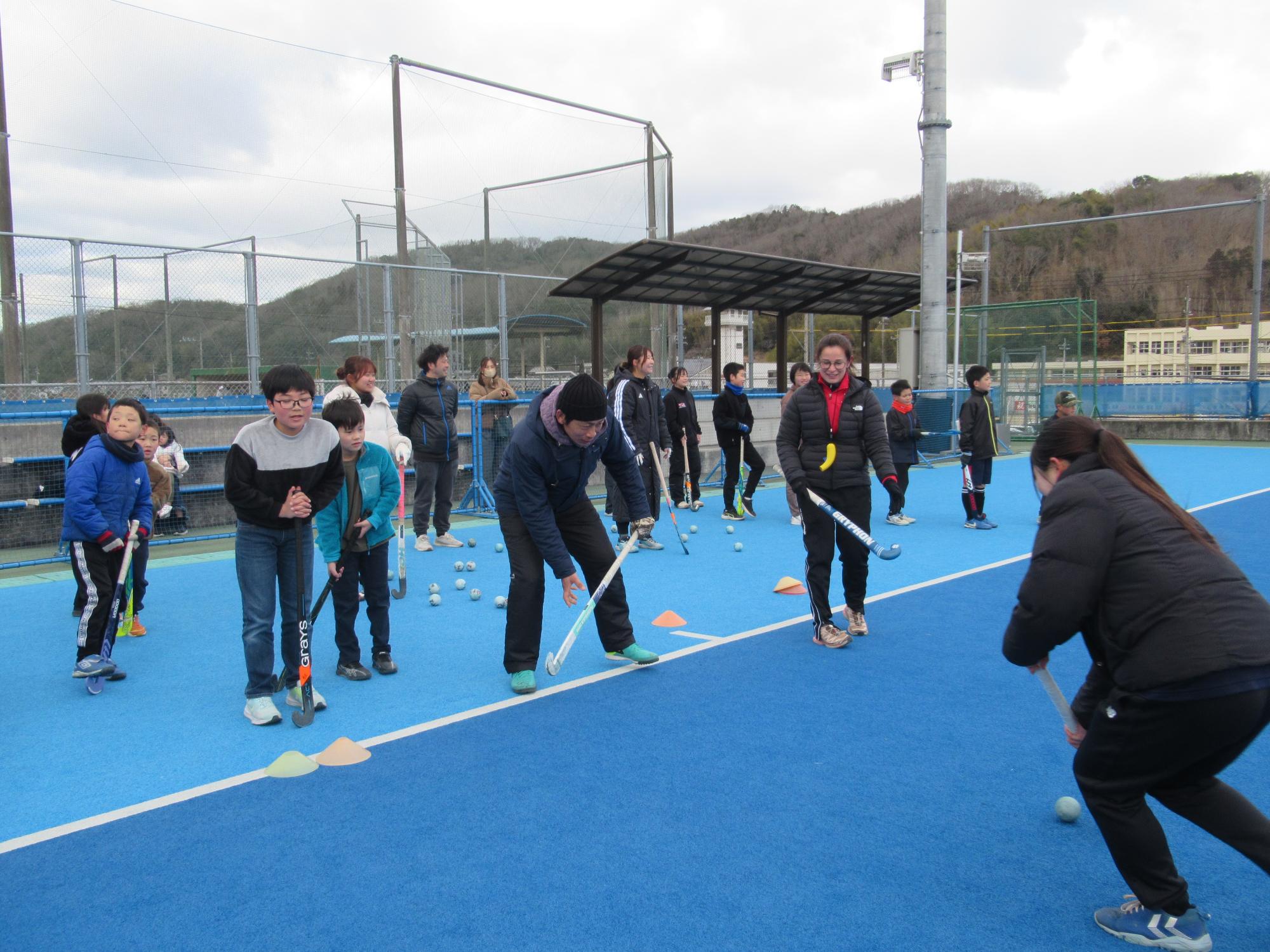 こどもも大人も一緒にホッケーにチャレンジする様子