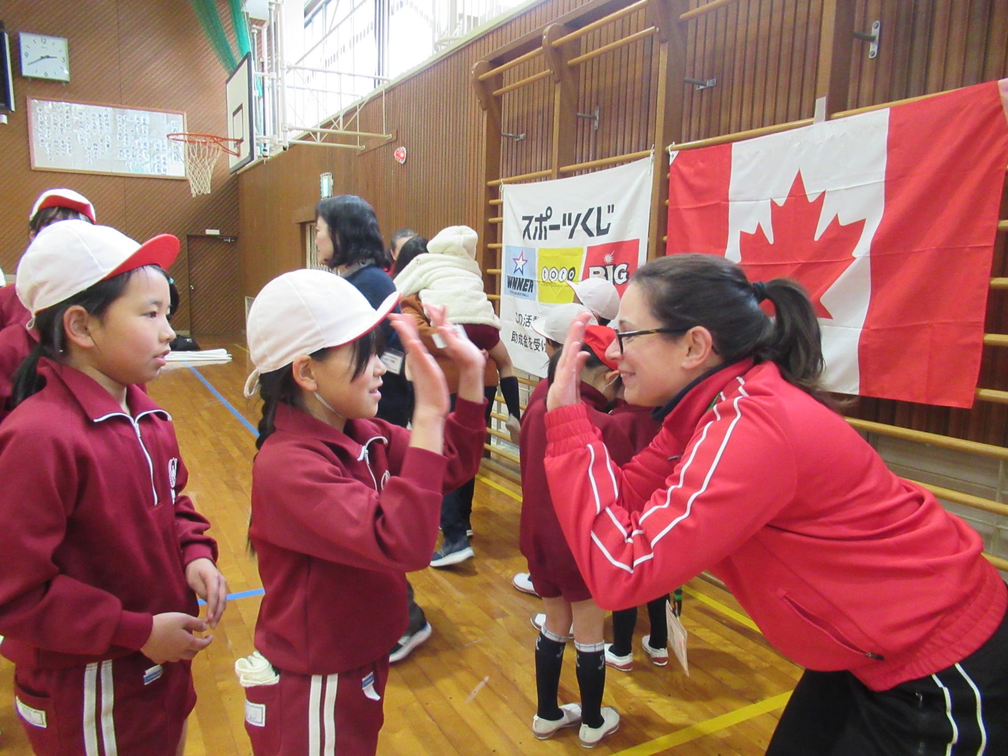ハイタッチでコーチにさようならをする小学生