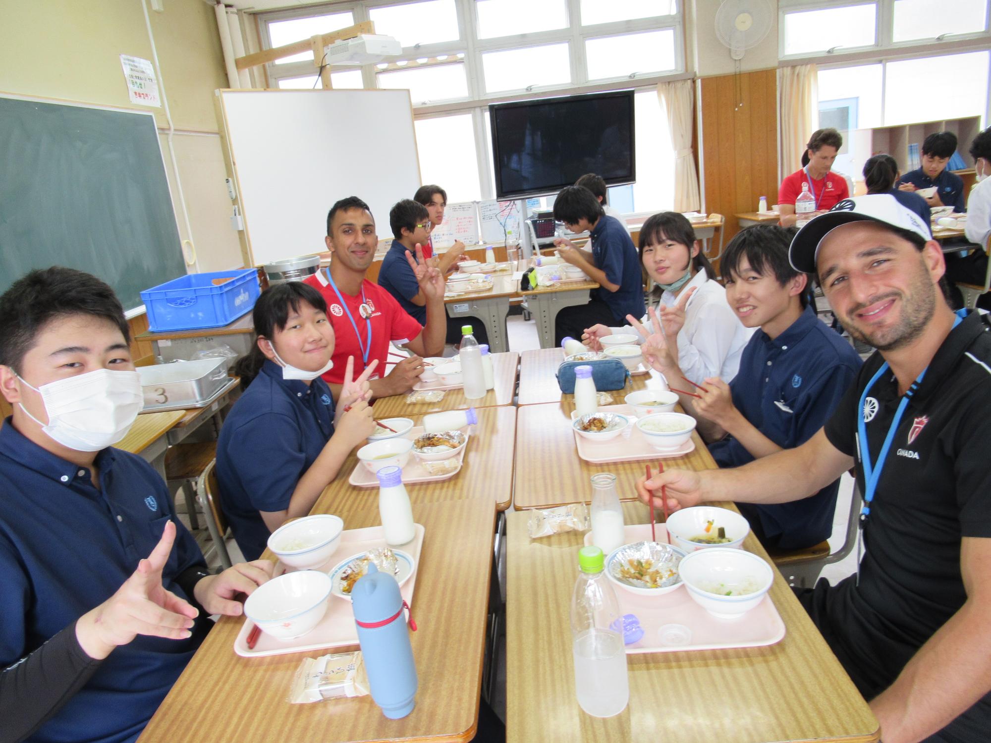 談笑しながら給食を食べる吉井中学生とカナダ代表選手たち