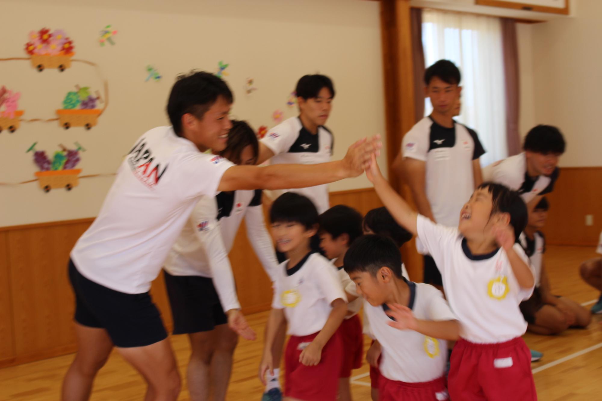 日本代表選手と笑顔でハイタッチする園児