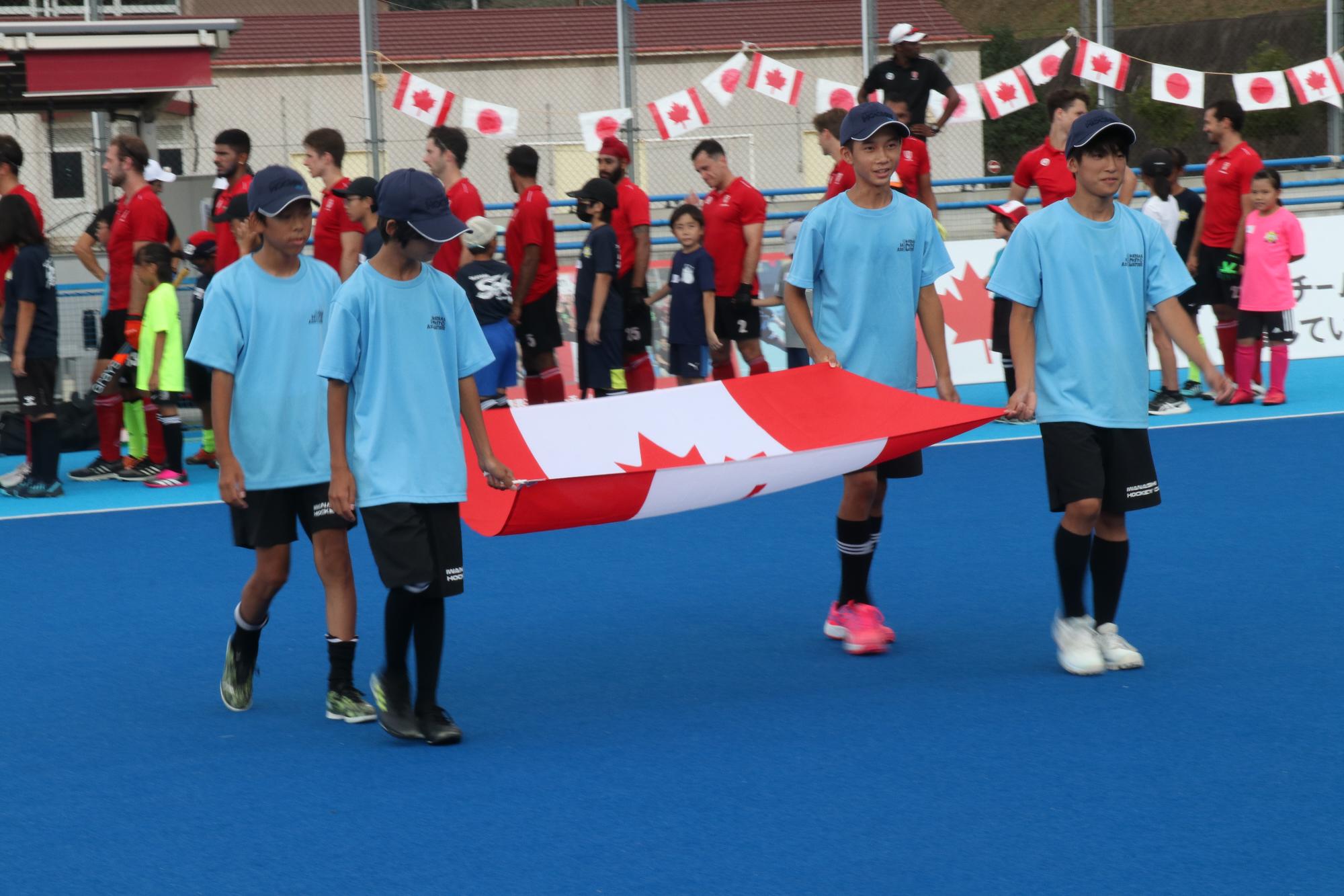 カナダ国旗を持って入場する磐梨中学校ホッケー部員