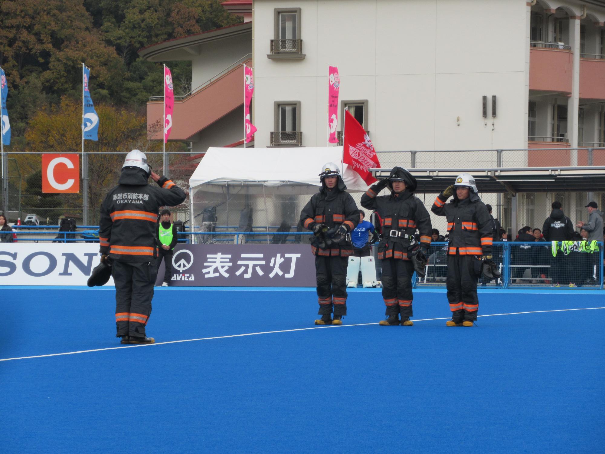 消防本部のハーフタイムパフォーマンスで敬礼をする消防士