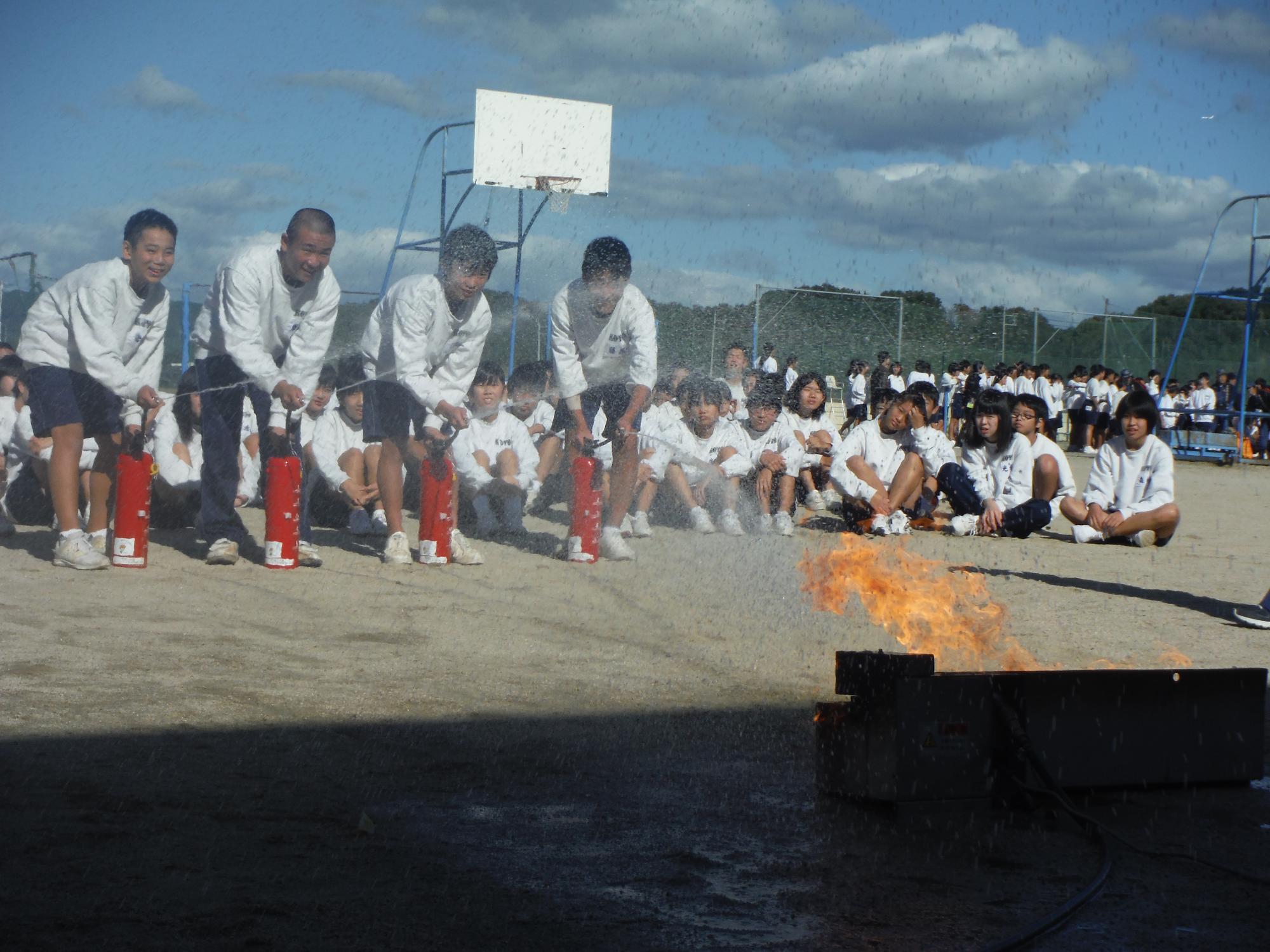 水消火器を使って火を消す中学生