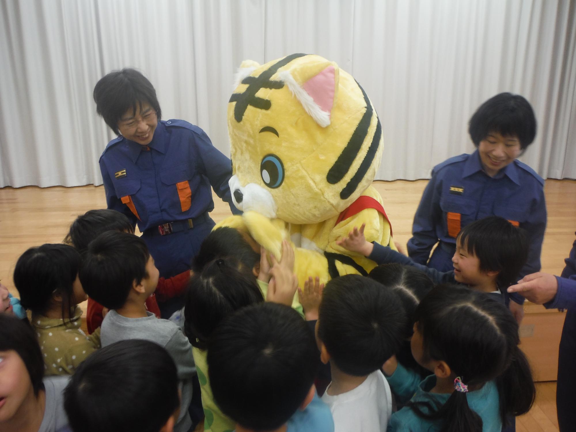 トラの着ぐるみと戯れる子供たちの画像