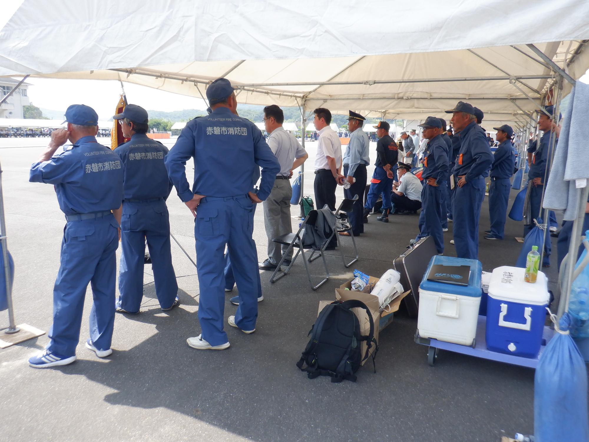 テントの中で選手を見つめる団幹部