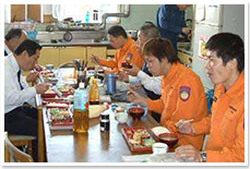 昼食を食べる職員や消防士たちの写真