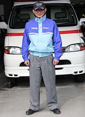 救急車の前で感染防止衣を着て立つ職員の写真